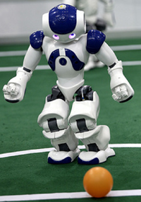 Aldebaran Nao humanoid robot playing soccer.