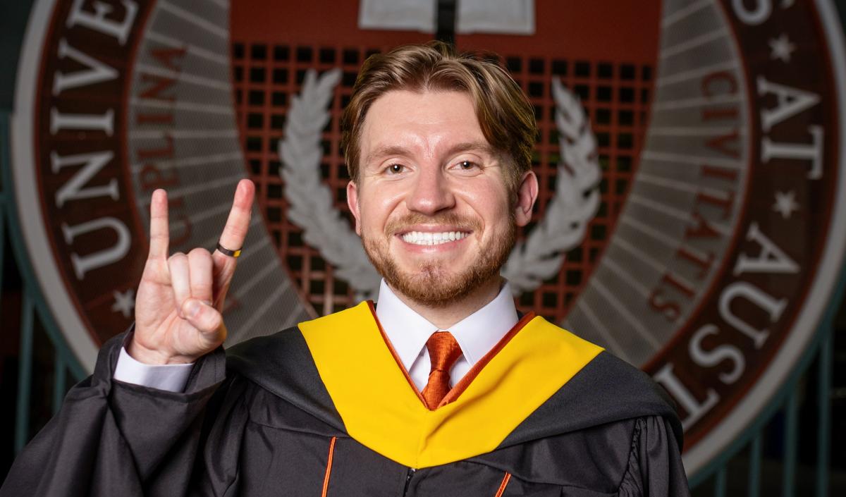 Carter posing in front of the UT seal