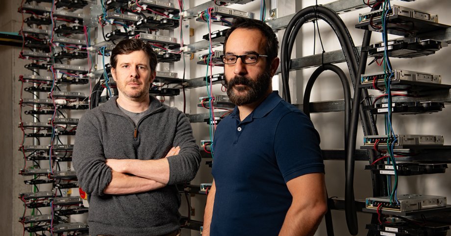 Alex Demarkis, right, and Adam Klivans, left, in front of the GPU computing cluster powering the Center for Generative AI.