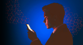 A young man gazes into a digital device.