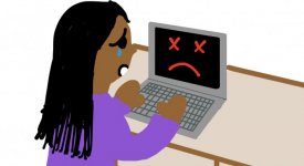A girl tearfully looks at her broken computer.