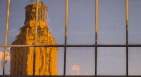 The University of Texas at Austin tower reflected in glass building