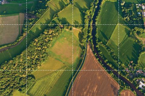 Aerial image showing different types of land use, including farming, forest and housing.