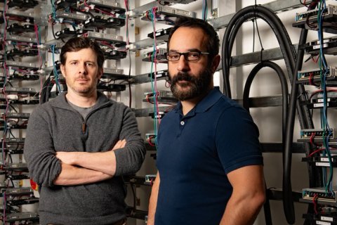 Alex Demarkis, right, and Adam Klivans, left, in front of the GPU computing cluster powering the Center for Generative AI.