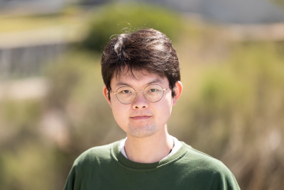 Chengeng Xu in a green shirt standing outside.
