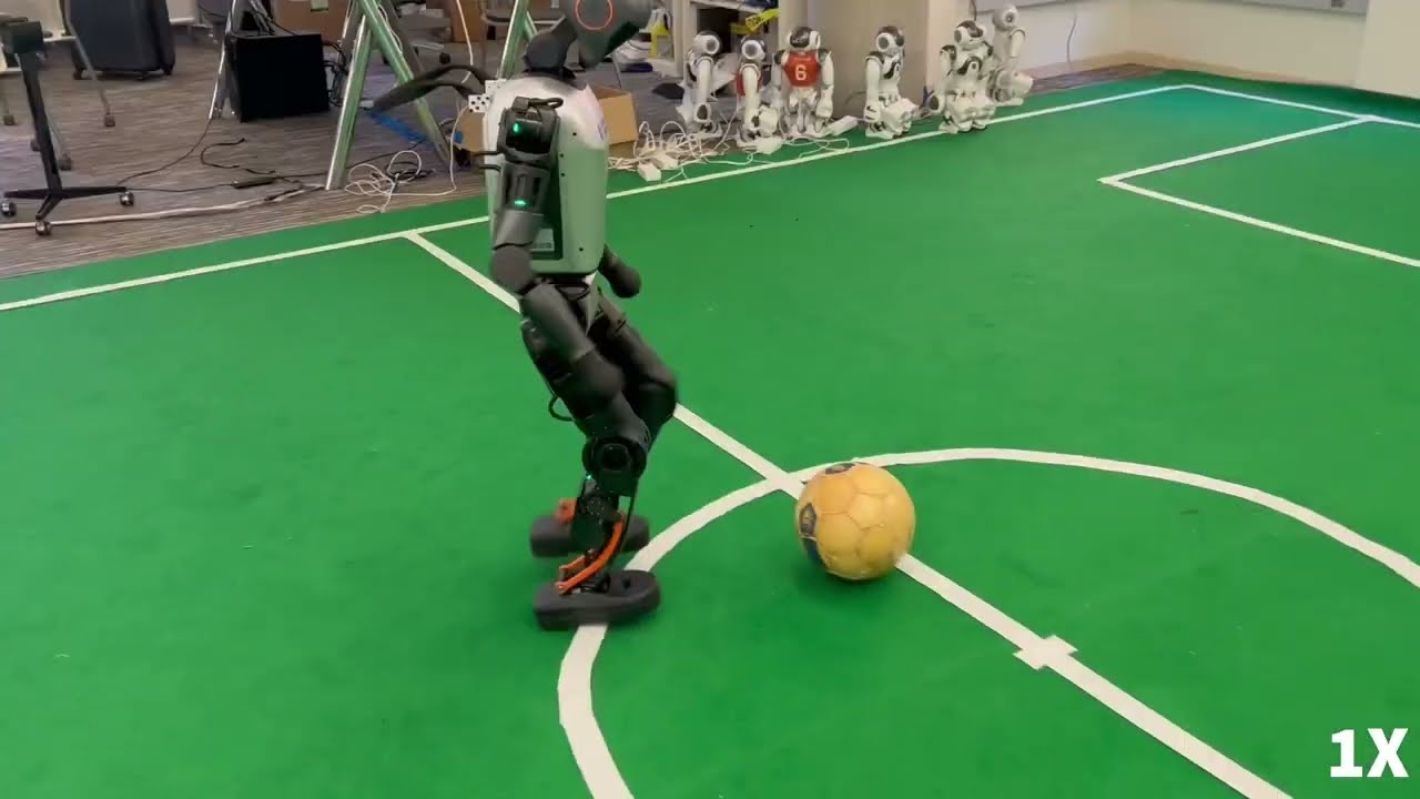 Booster T1 robot dribbling a ball on an indoor soccer field