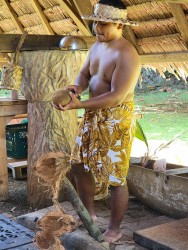 man in Chamorran outfit preparing coconut